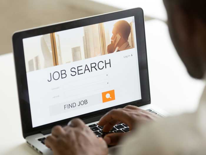 Man applying for a job online. Shutterstock.com/fizkes