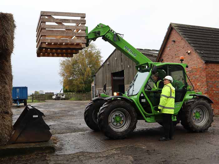 Marcus Nicholson guides a young trainee on how to operate a telehandler, lifting objects at height during a training course at VA Training, Northallerton.